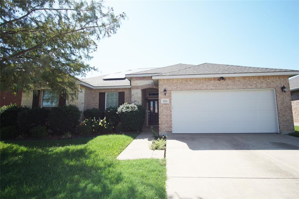 a front view of a house with a yard and a garage