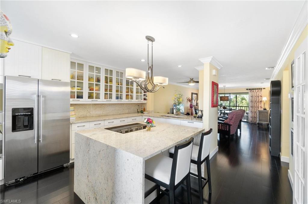 a kitchen with stainless steel appliances granite countertop table chairs and a refrigerator