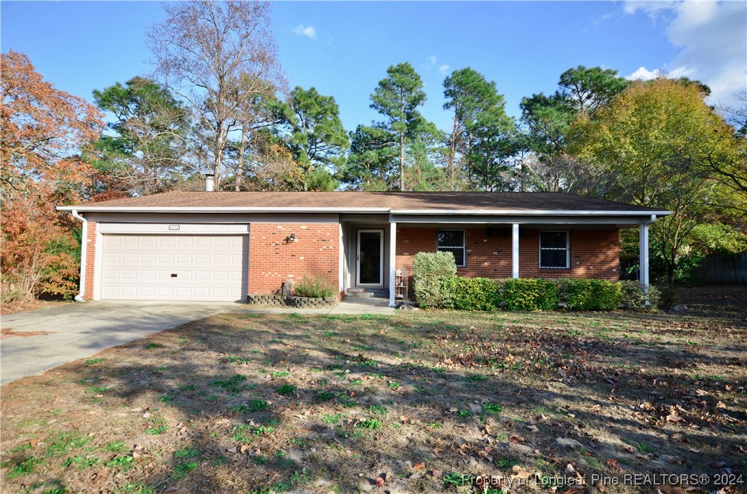 a front view of house with yard and trees in the background