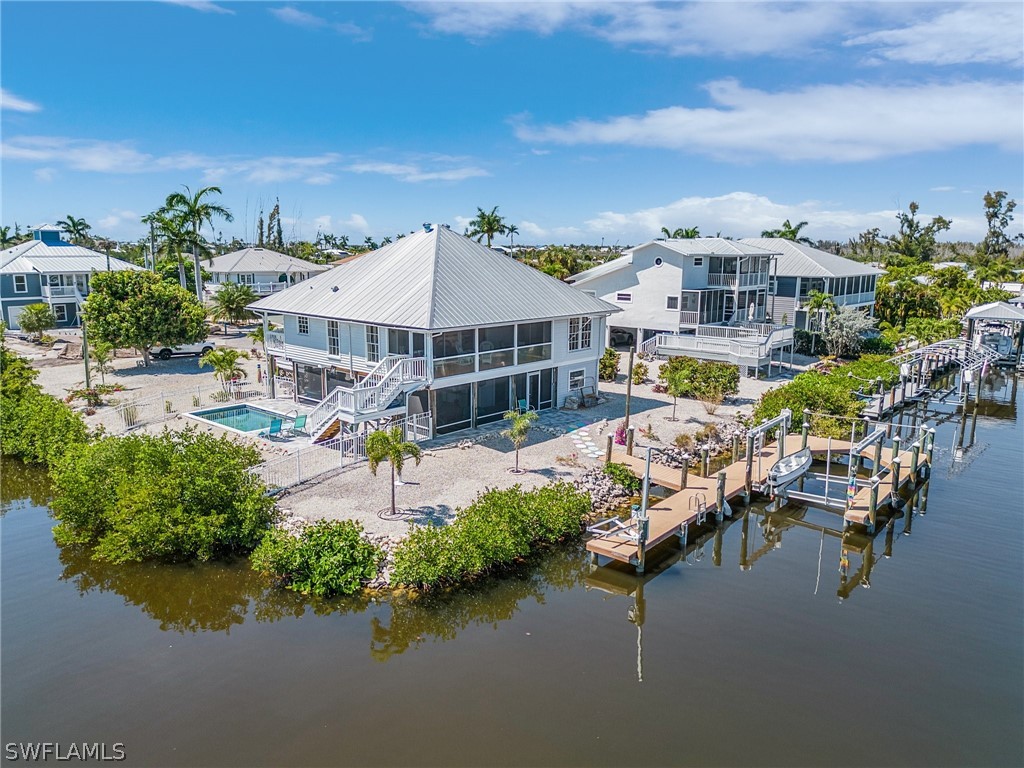 an aerial view of a house with swimming pool and outdoor seating