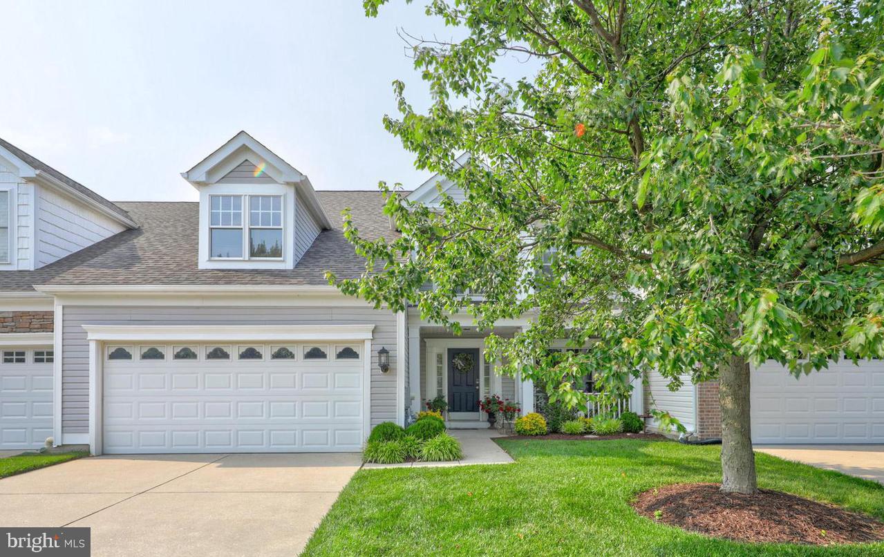 a front view of a house with a yard and trees