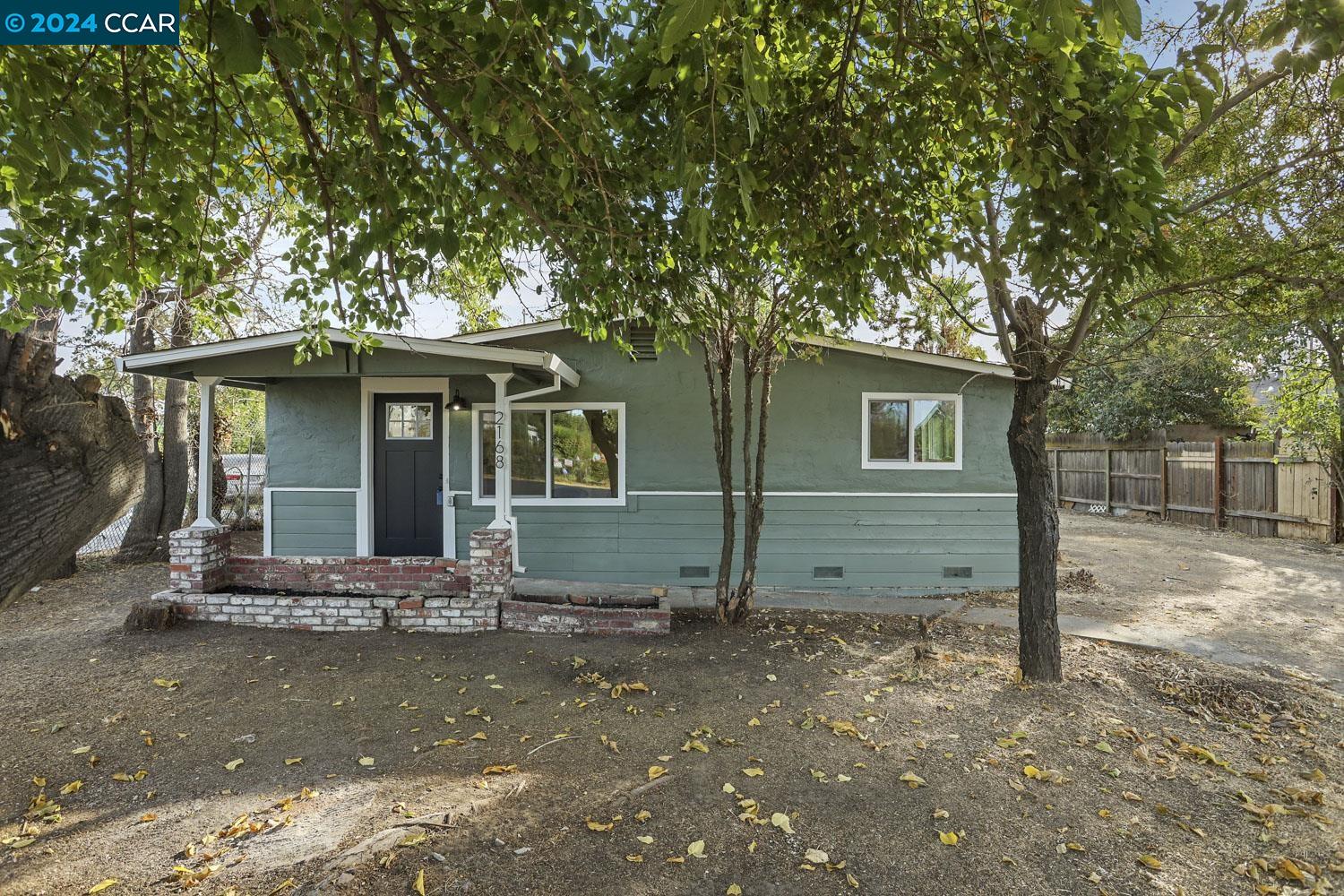 a front view of a house with a tree