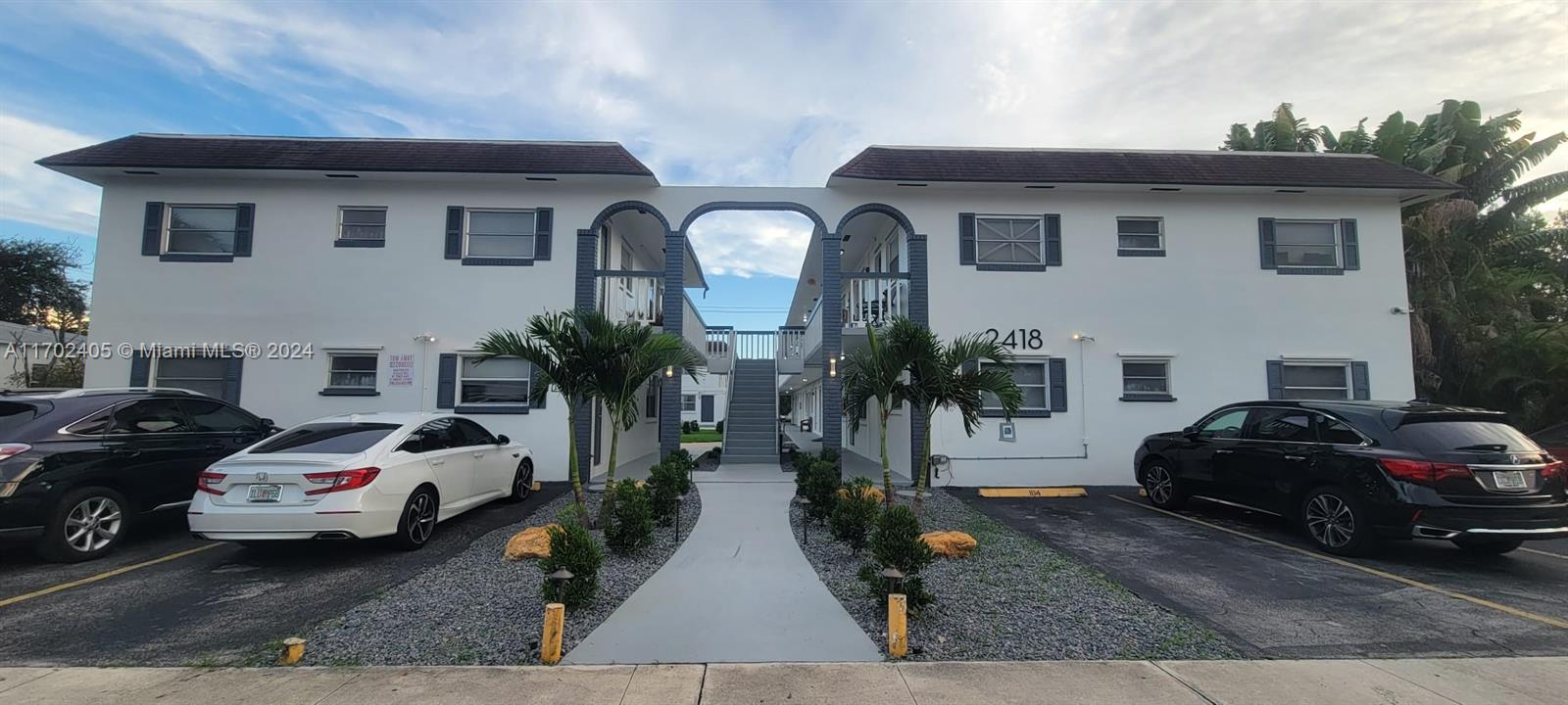 a couple of cars parked in front of a house