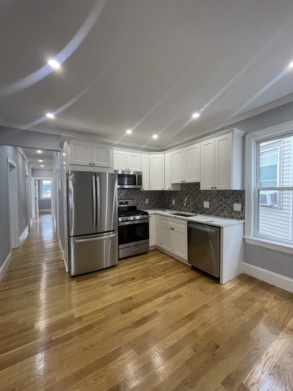 a kitchen with stainless steel appliances kitchen island granite countertop a refrigerator and a stove top oven