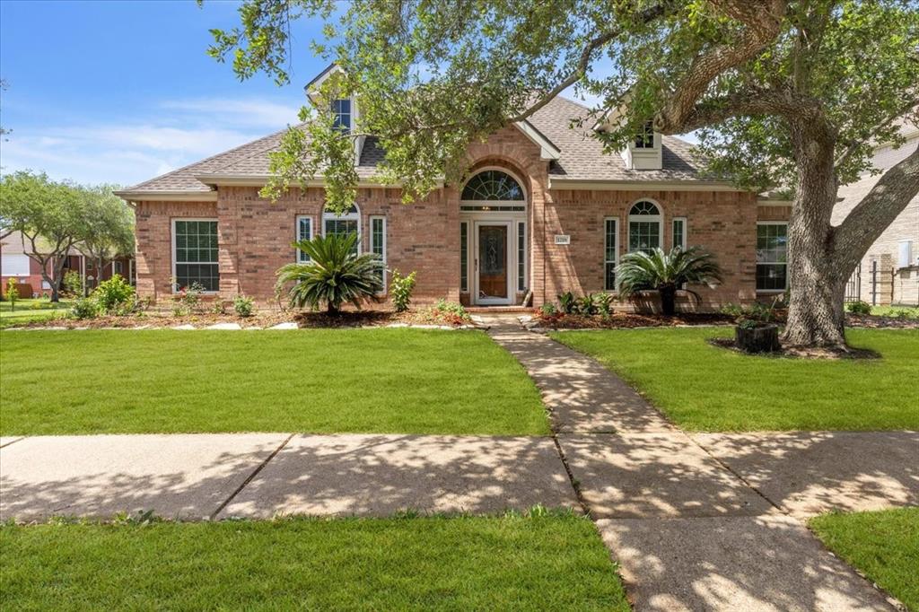 a front view of a house with a yard and trees