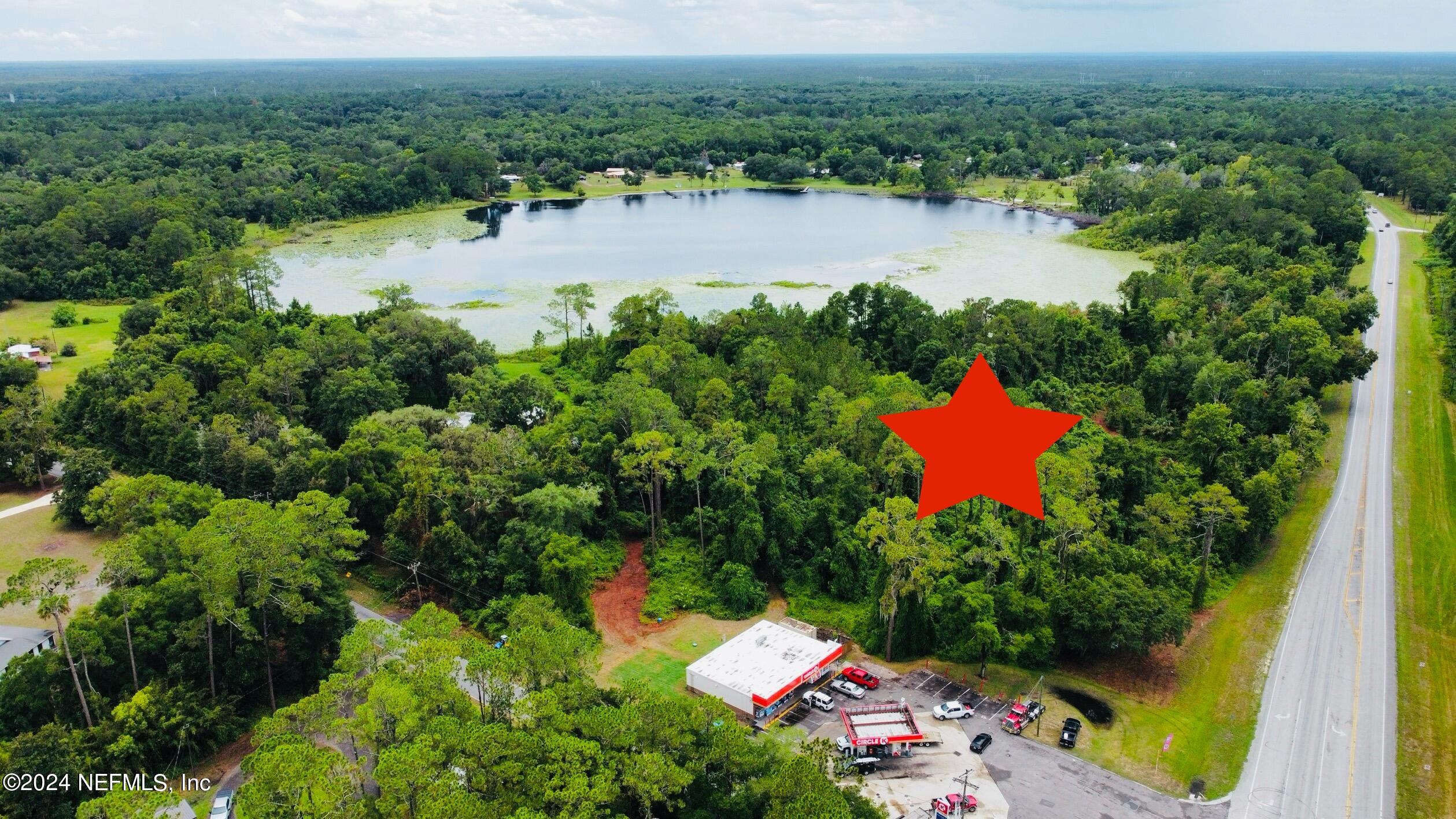 an aerial view of lake residential house with outdoor space and trees around