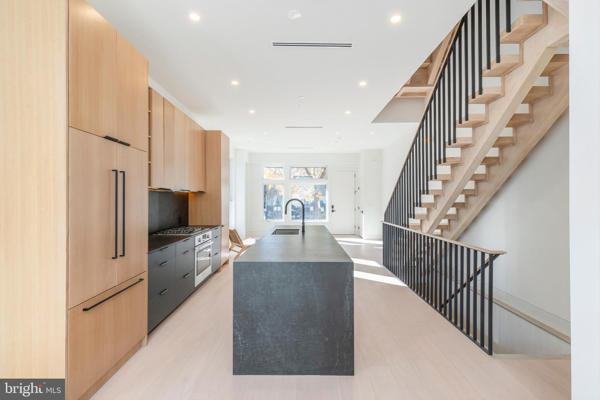 a view of a living room with wooden floor and staircase