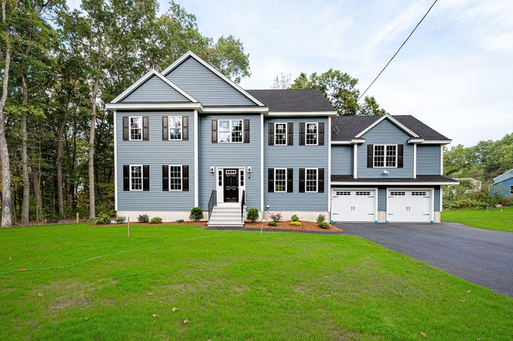 a front view of a house with a yard and trees