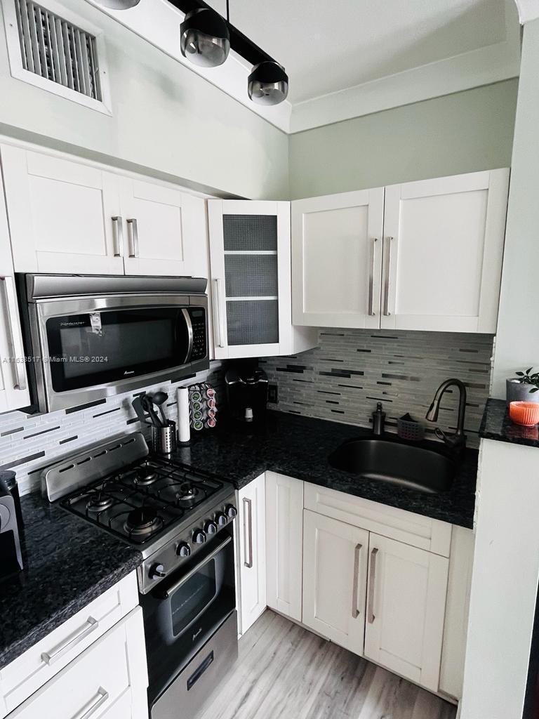 a kitchen with a sink stove and microwave