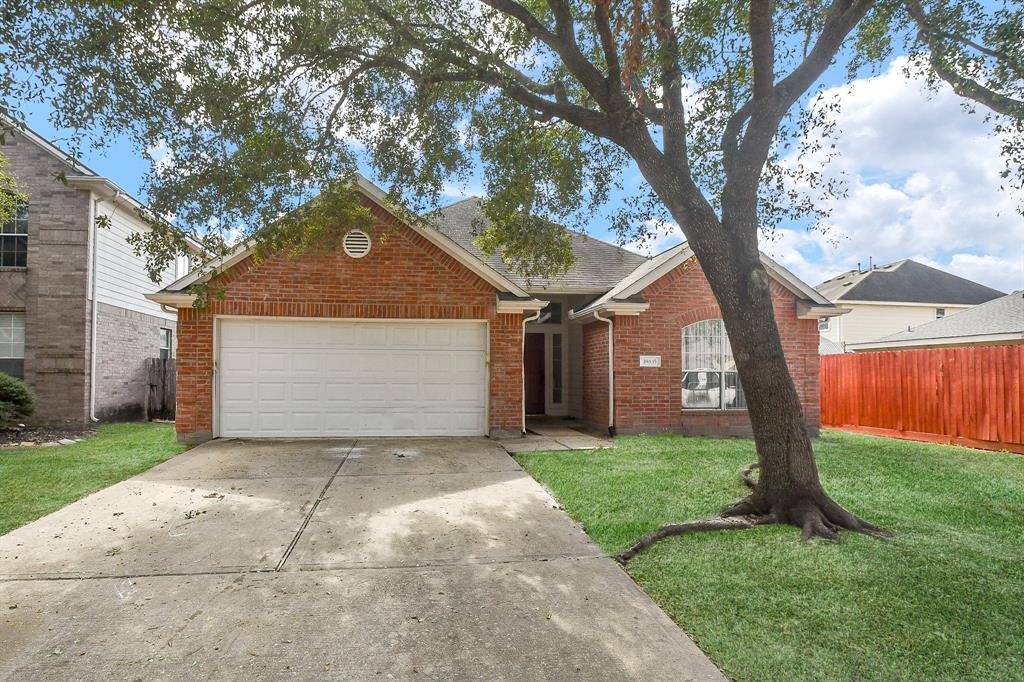 a front view of a house with a yard and tree