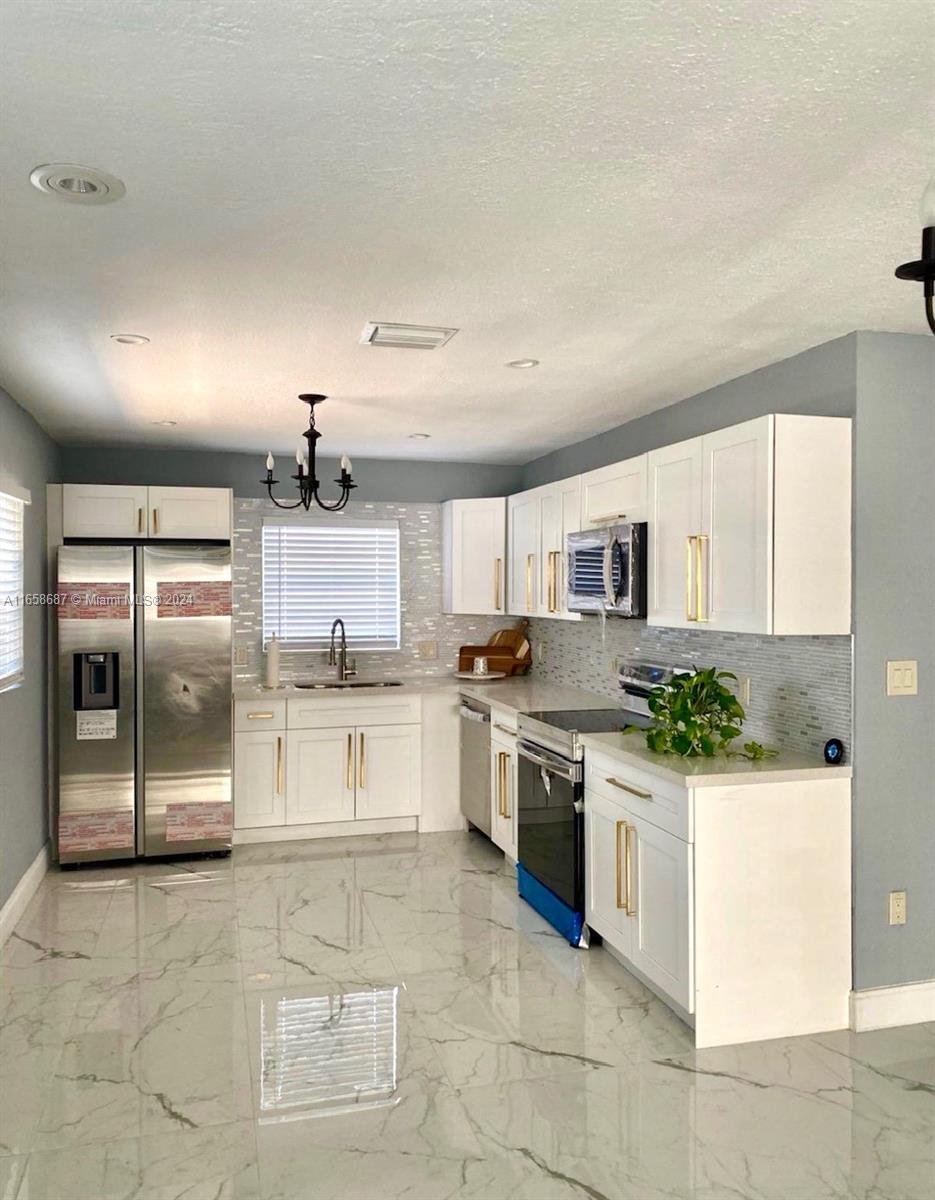 a kitchen with stainless steel appliances kitchen island granite countertop a stove and cabinets