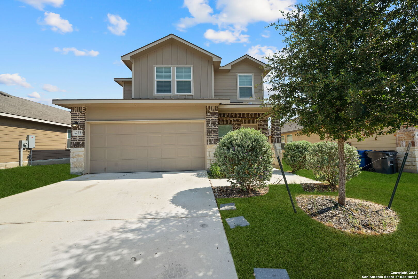 a front view of a house with a yard and garage