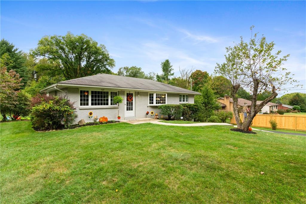 a front view of a house with yard and green space