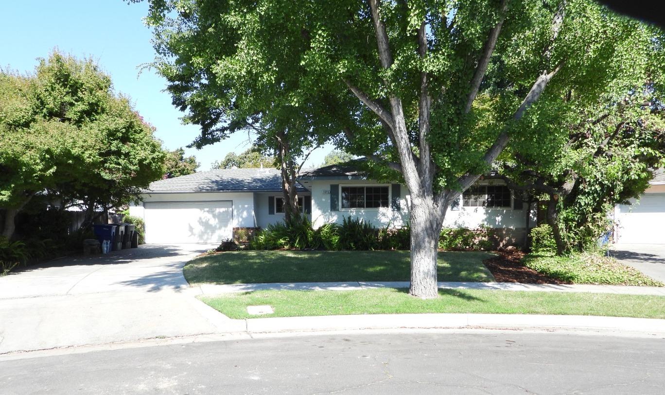 a front view of a house with a yard and trees