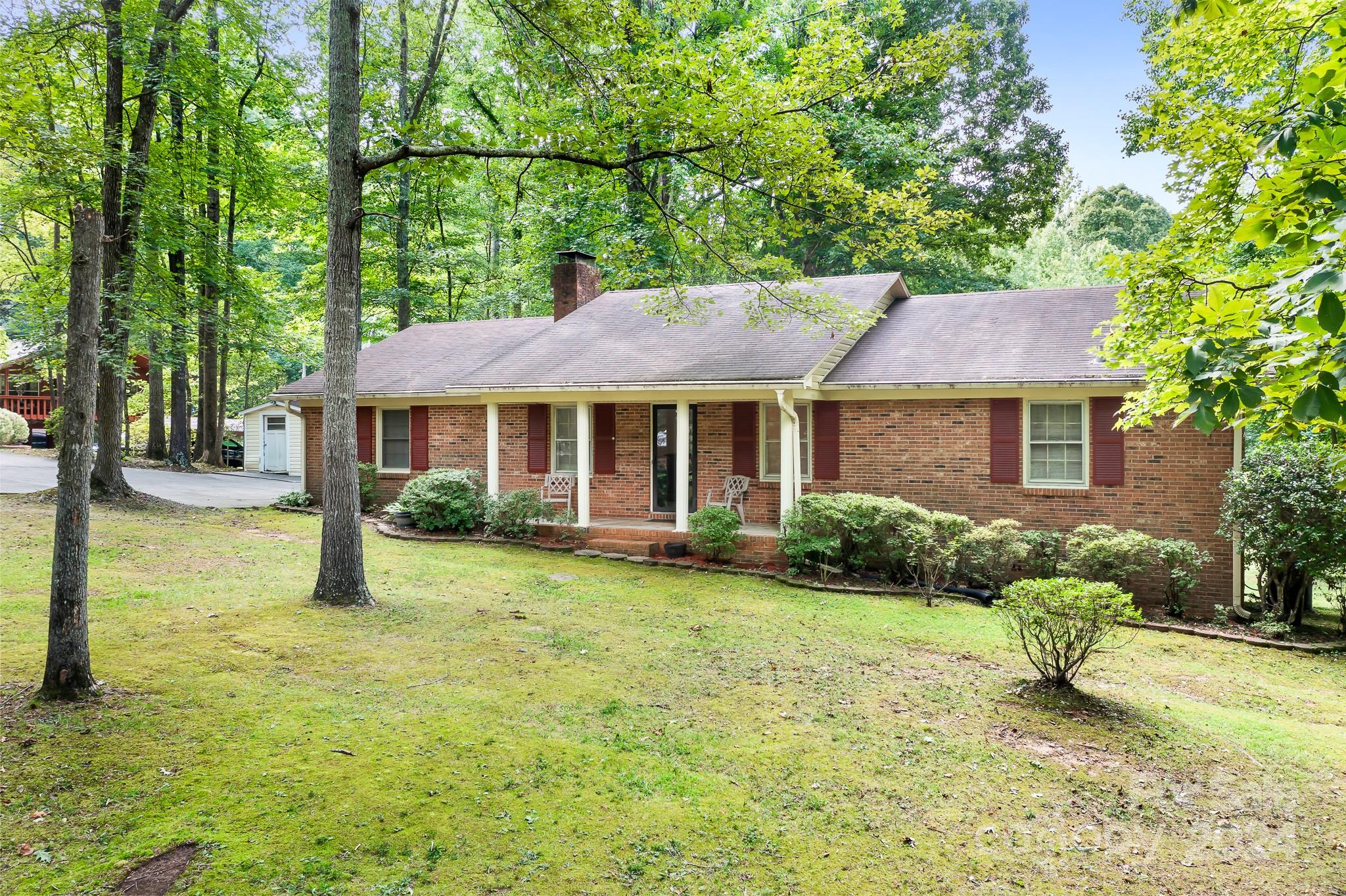 a front view of a house with a yard and trees