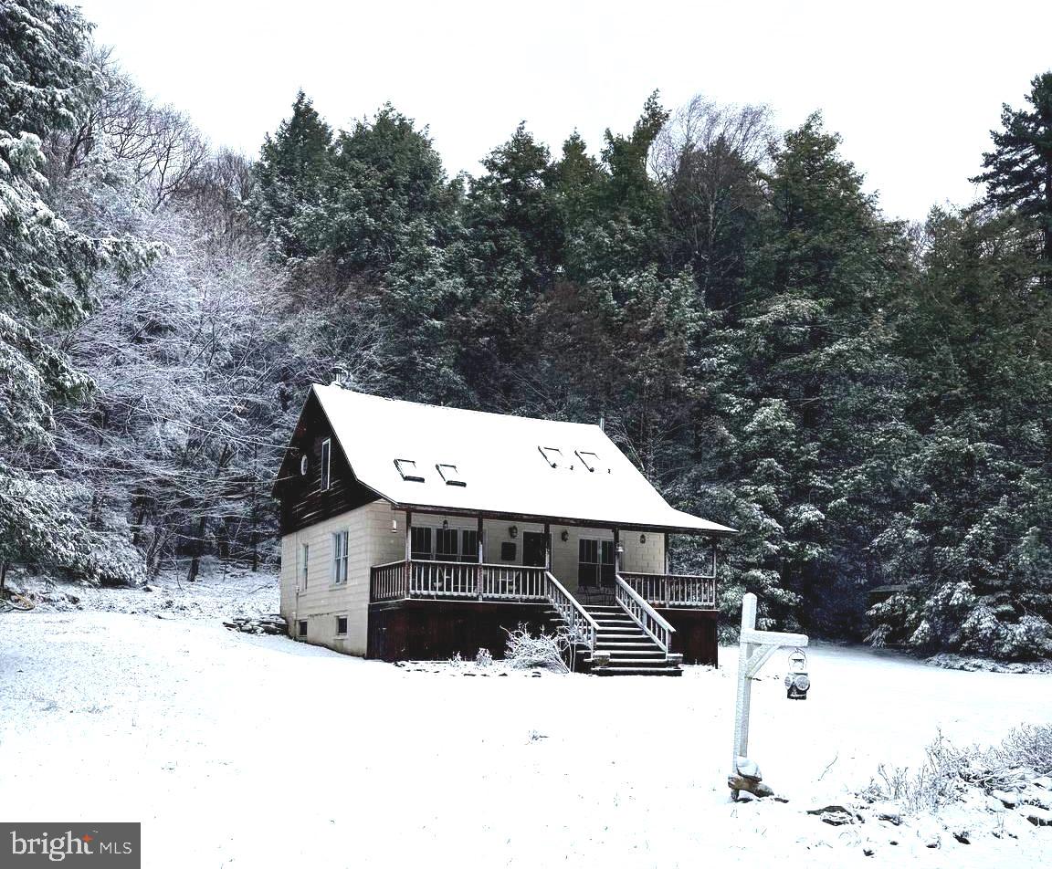 a view of a house with a yard covered in snow