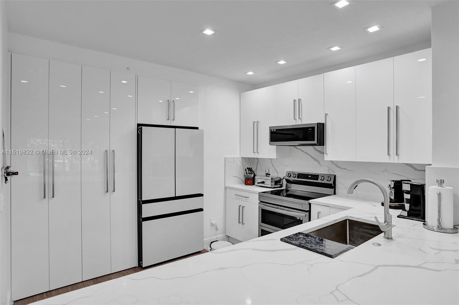 a kitchen with granite countertop white cabinets and stainless steel appliances