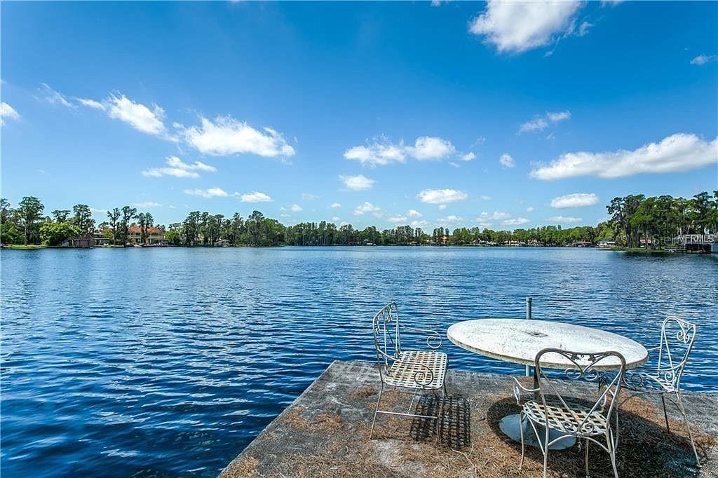 a view of a lake with table and chairs