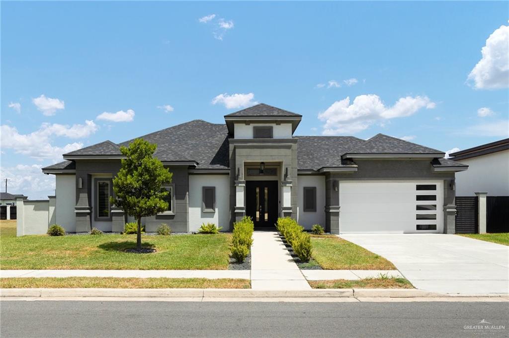 Prairie-style home featuring a front yard and a garage