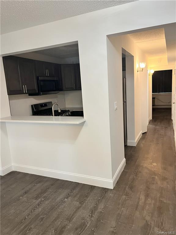 a view of a utility room with wooden floor and cabinet