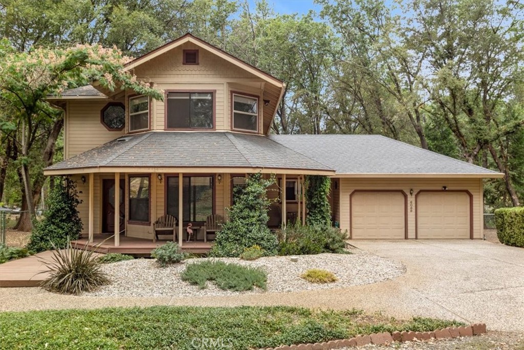 a front view of a house with a yard and potted plants