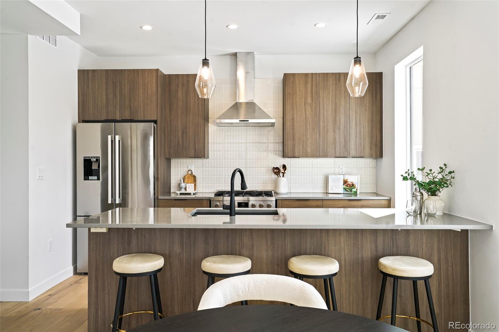 a kitchen with granite countertop a table chairs stove and refrigerator