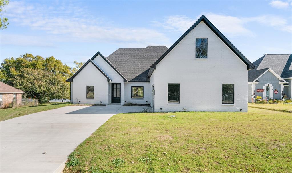 a front view of house with yard and trees in the background