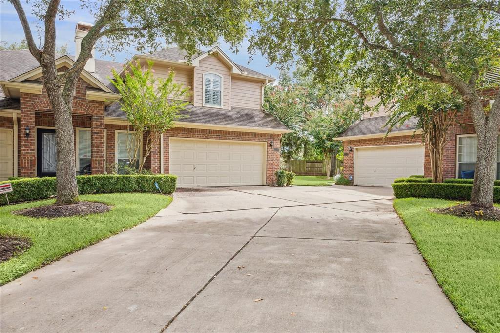 front view of a house with a yard and an trees