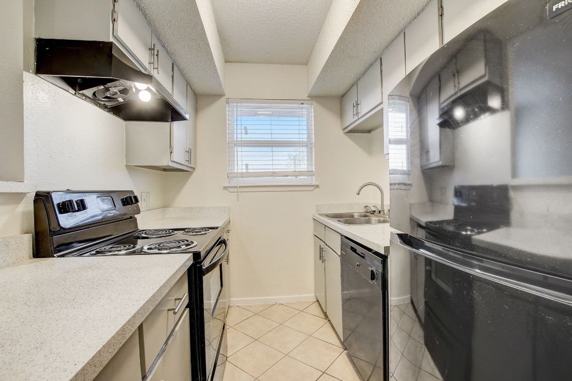 a kitchen with stainless steel appliances a sink a stove and a refrigerator