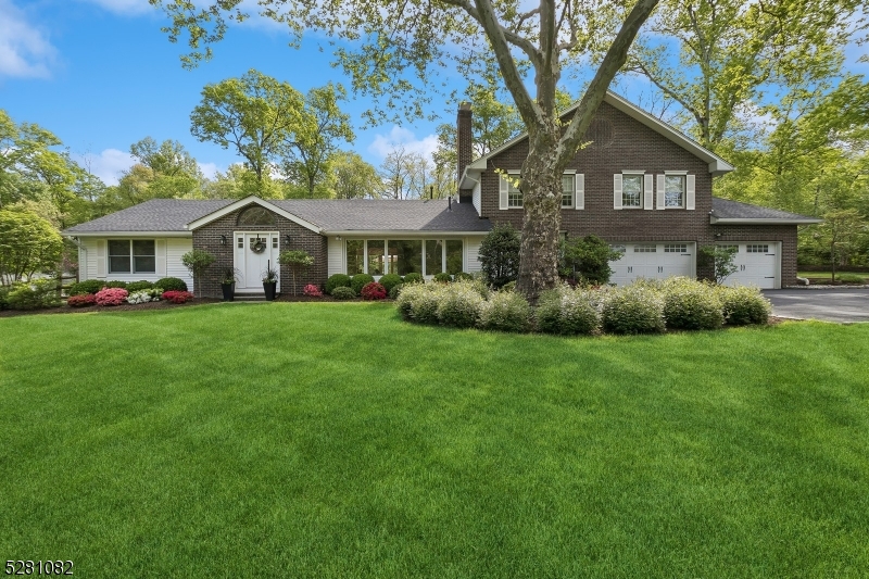 a front view of a house with a yard and trees