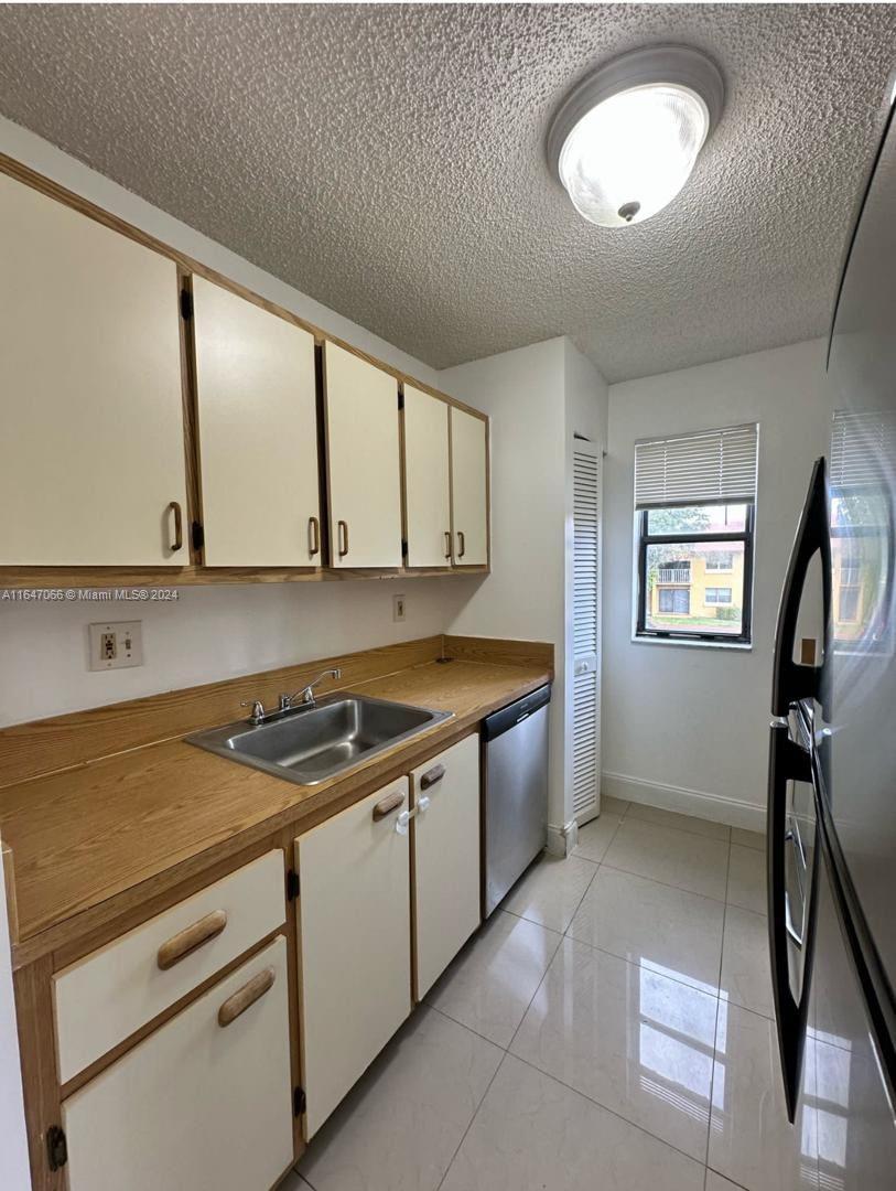 a kitchen that has a sink a stove and cabinets