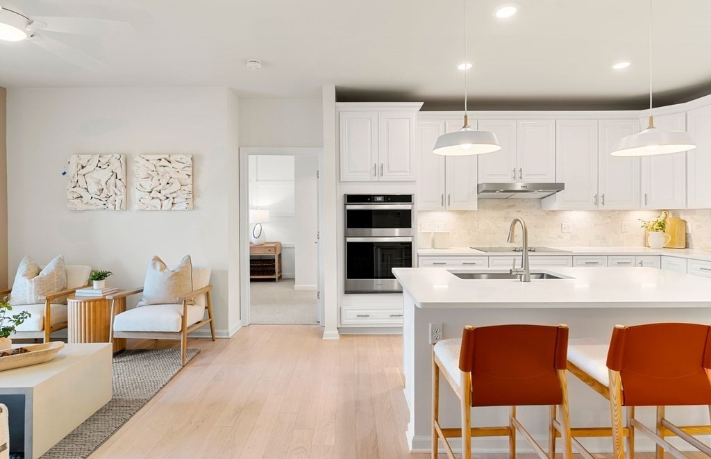 a kitchen with stainless steel appliances granite countertop a table and chairs in it