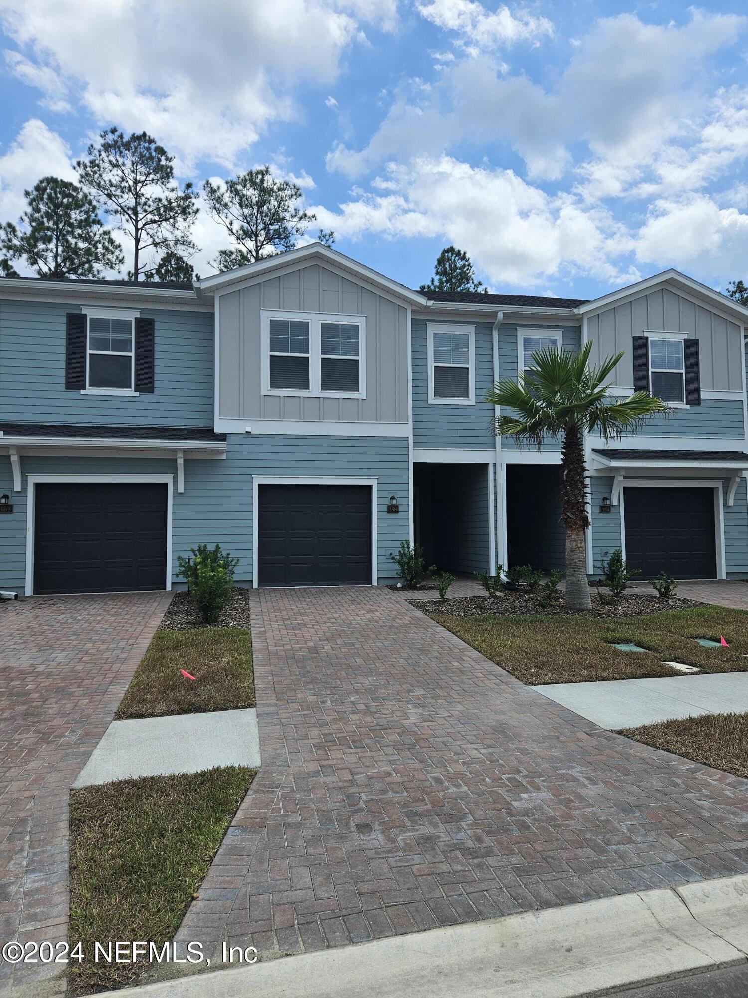 a front view of a house with a yard and a garage