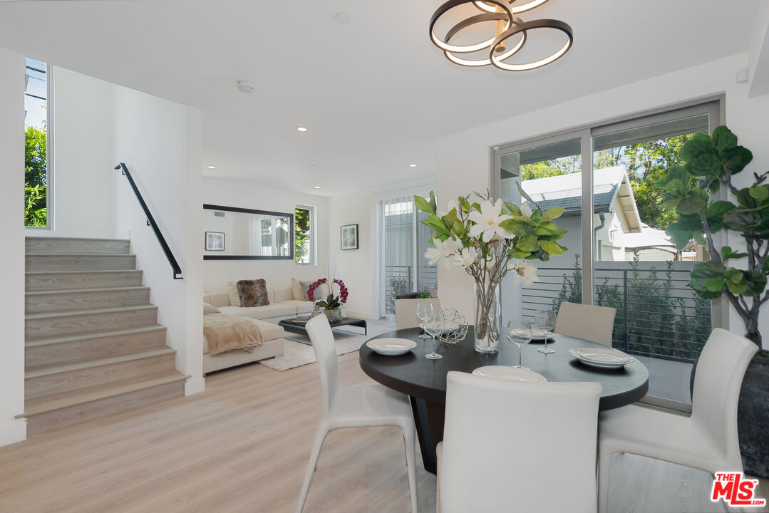 a living room with furniture potted plant and a large window