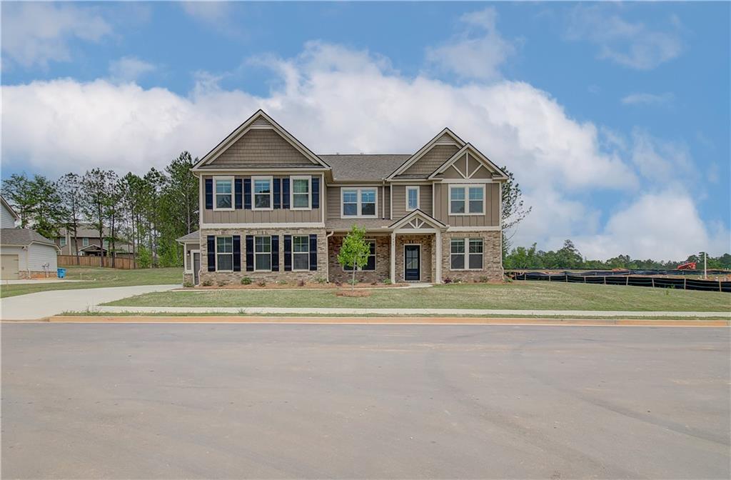 a front view of a house with a yard and lake view