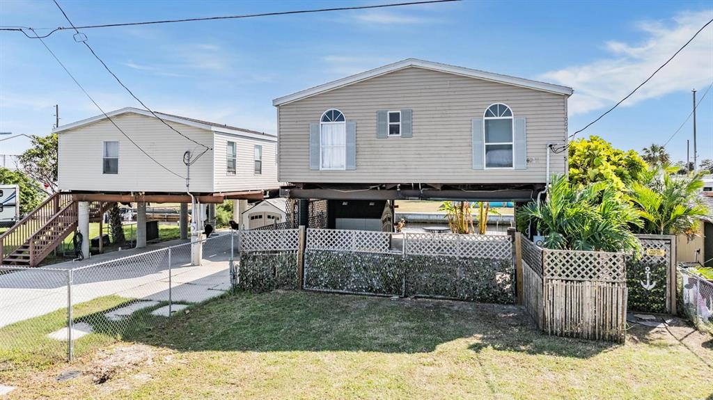 a view of a house with a small yard and wooden fence