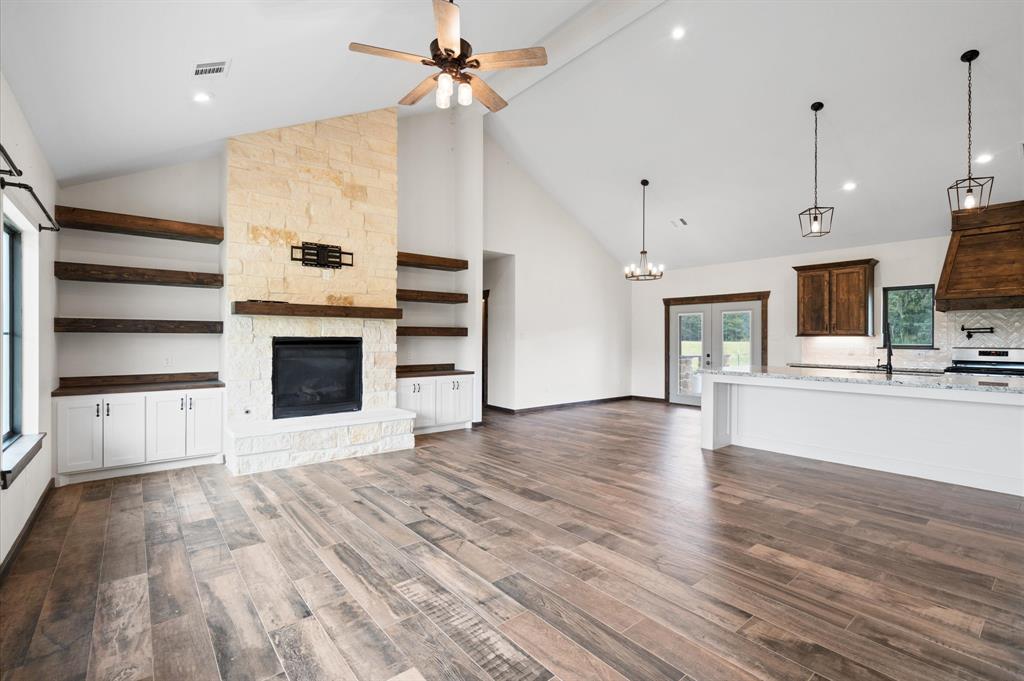 a view of empty room with wooden floor and fireplace