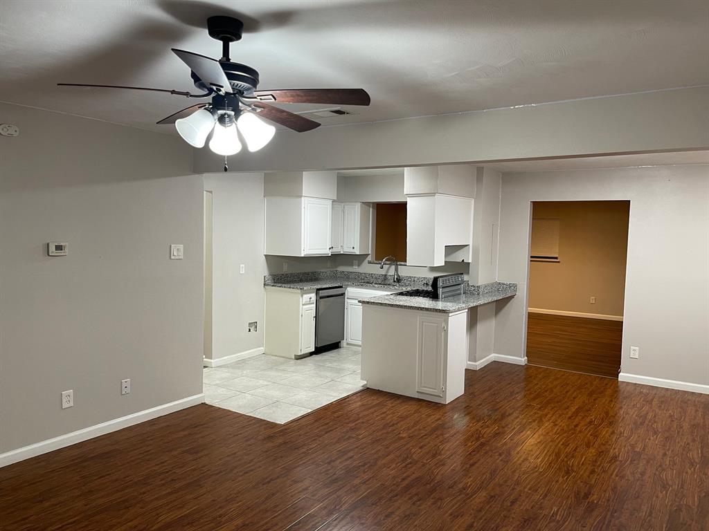 a kitchen with granite countertop a refrigerator and microwave