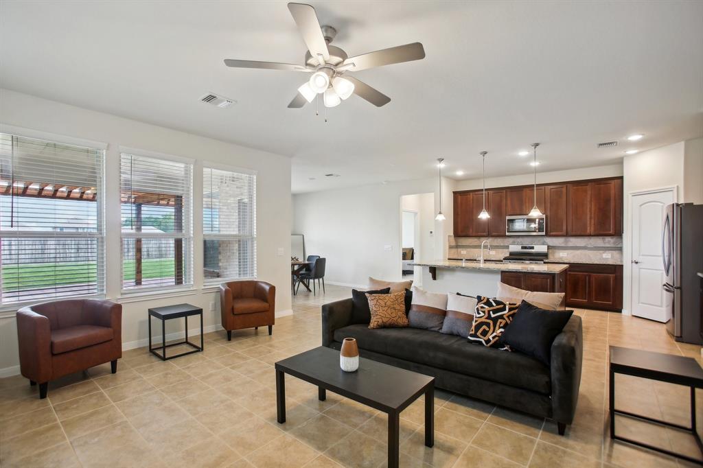 a living room with furniture kitchen view and a large window