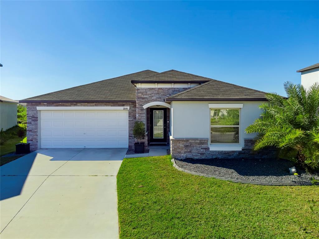 a front view of a house with a yard and garage