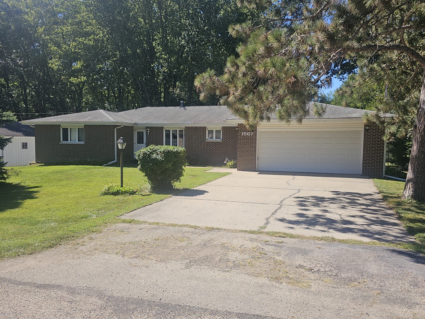 a front view of a house with yard and green space