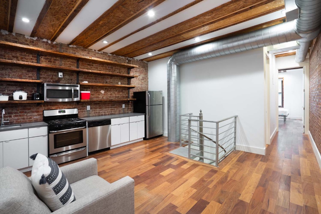 a kitchen with stainless steel appliances kitchen island granite countertop a sink cabinets and wooden floor