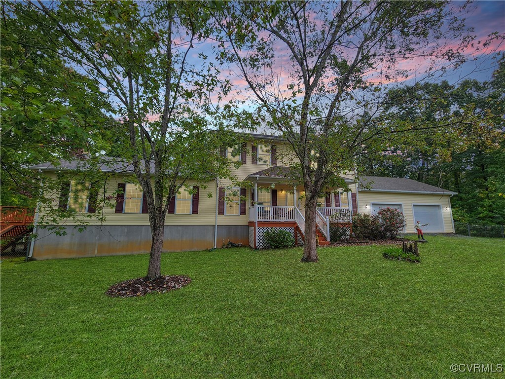 a front view of a house with garden and trees