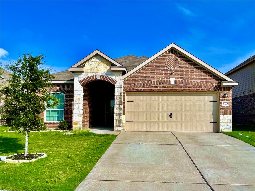 a front view of a house with a yard and garage