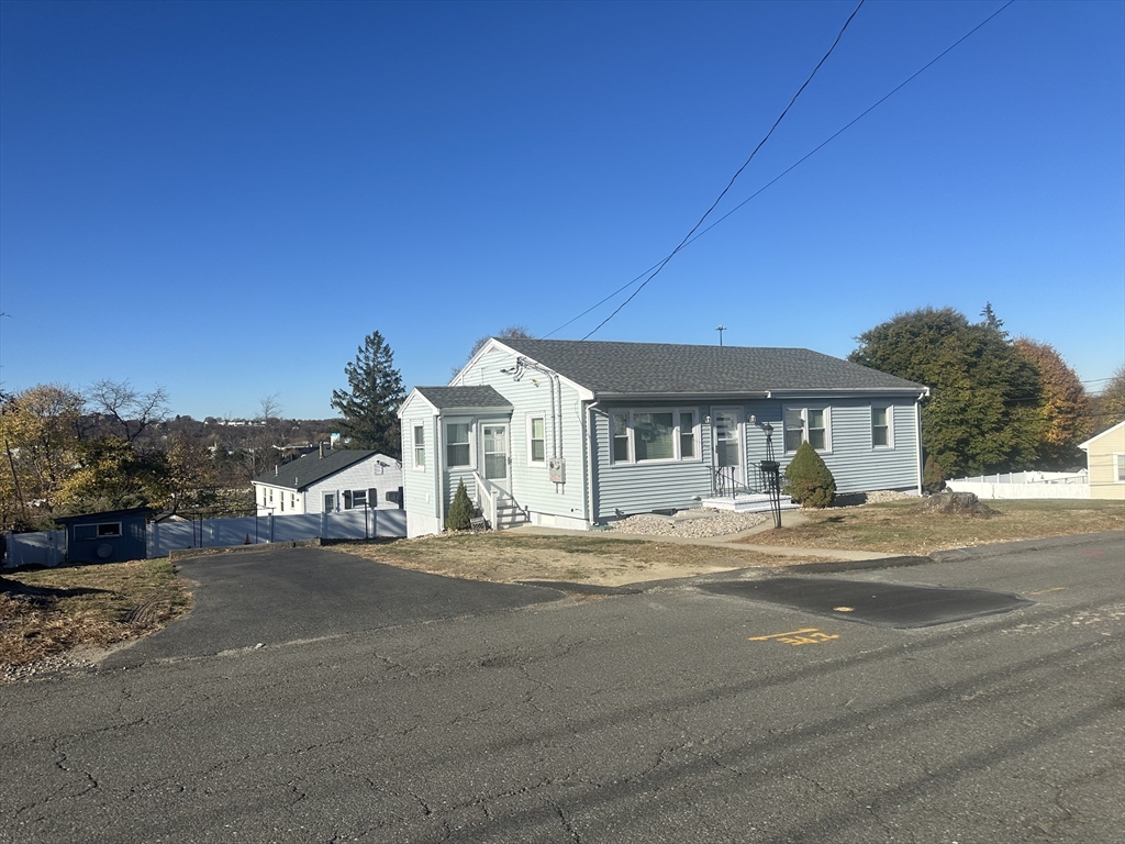 a view of a house with a patio and a yard