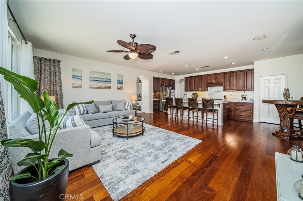 a living room with furniture kitchen view and a potted plant