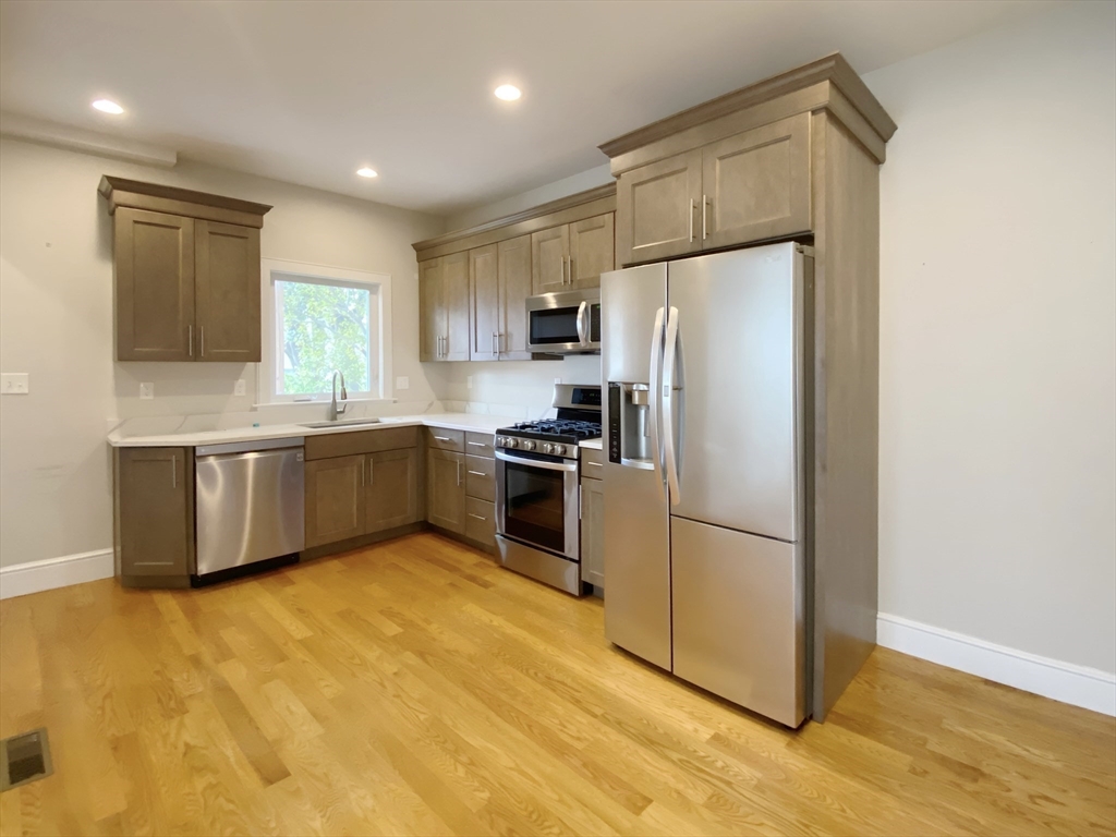 a kitchen with stainless steel appliances a refrigerator sink and cabinets