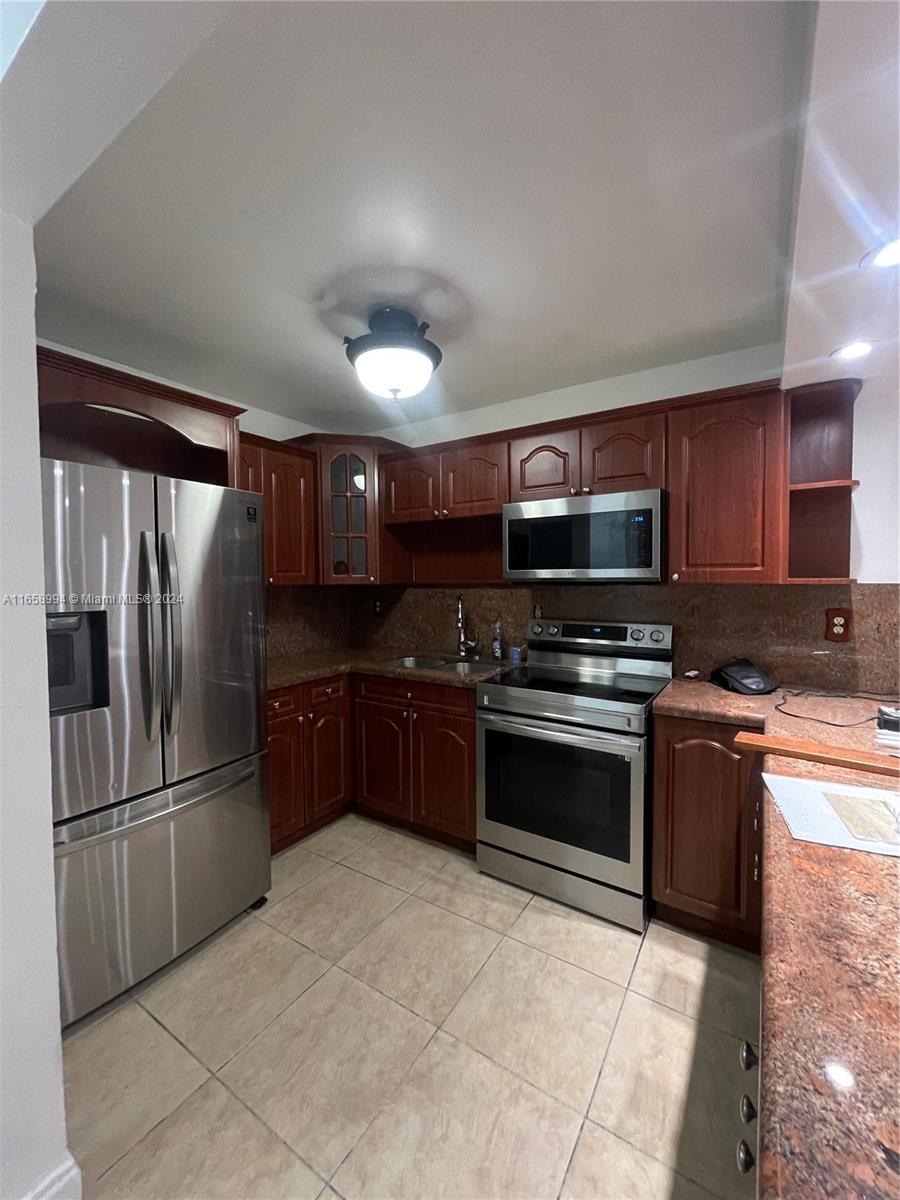 a kitchen with stainless steel appliances granite countertop a refrigerator and a stove top oven