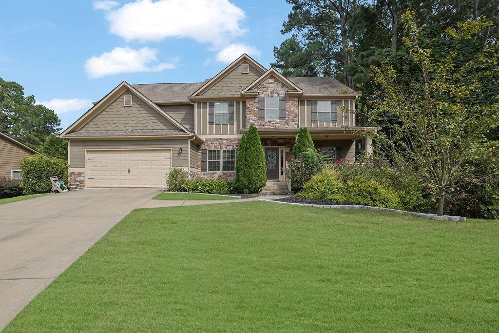 a front view of a house with a garden and plants