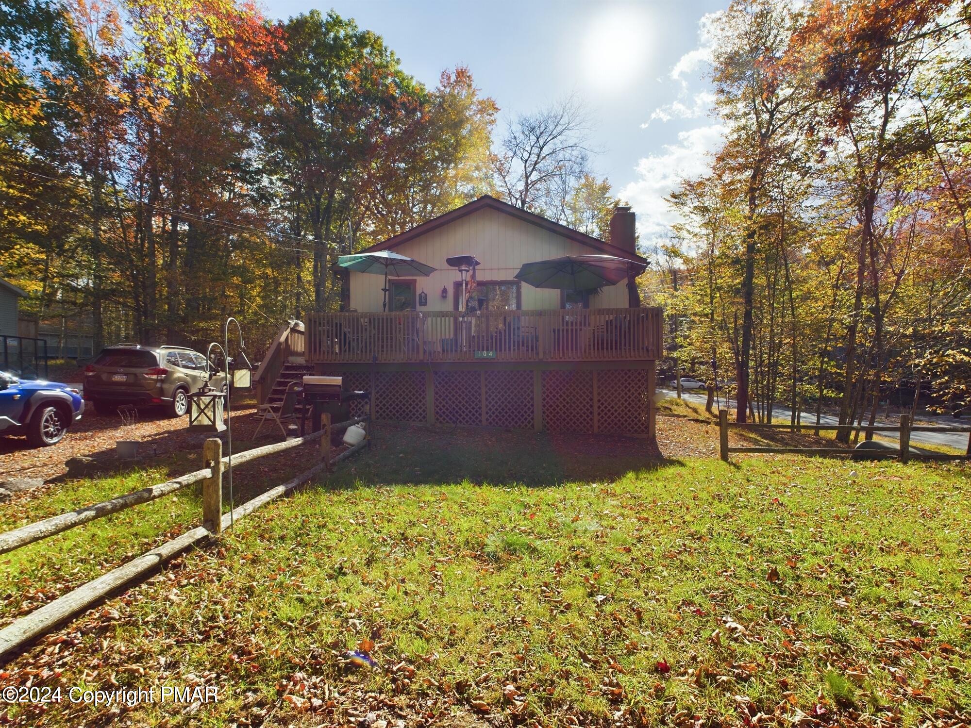 a view of a backyard with table and chairs and a large tree